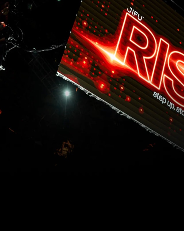 The glowing RISE sign on stage