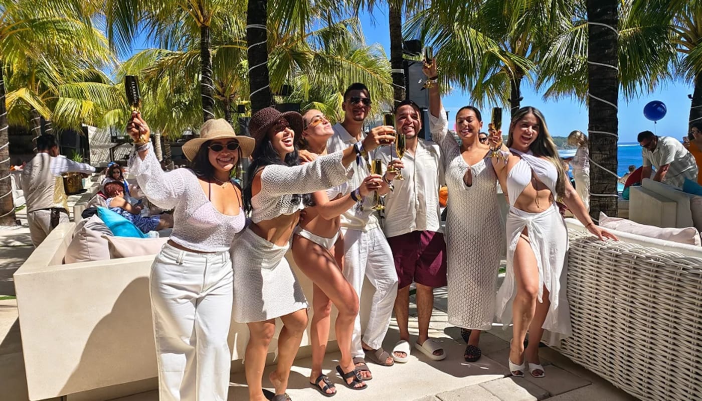 Guests dressed in white under the palms