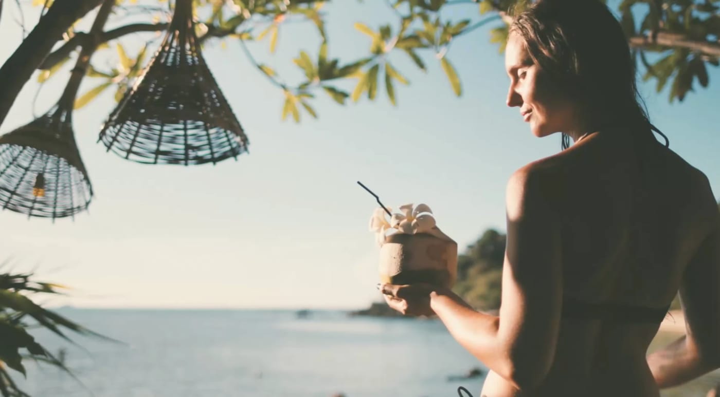 A guest with a drink by the sea